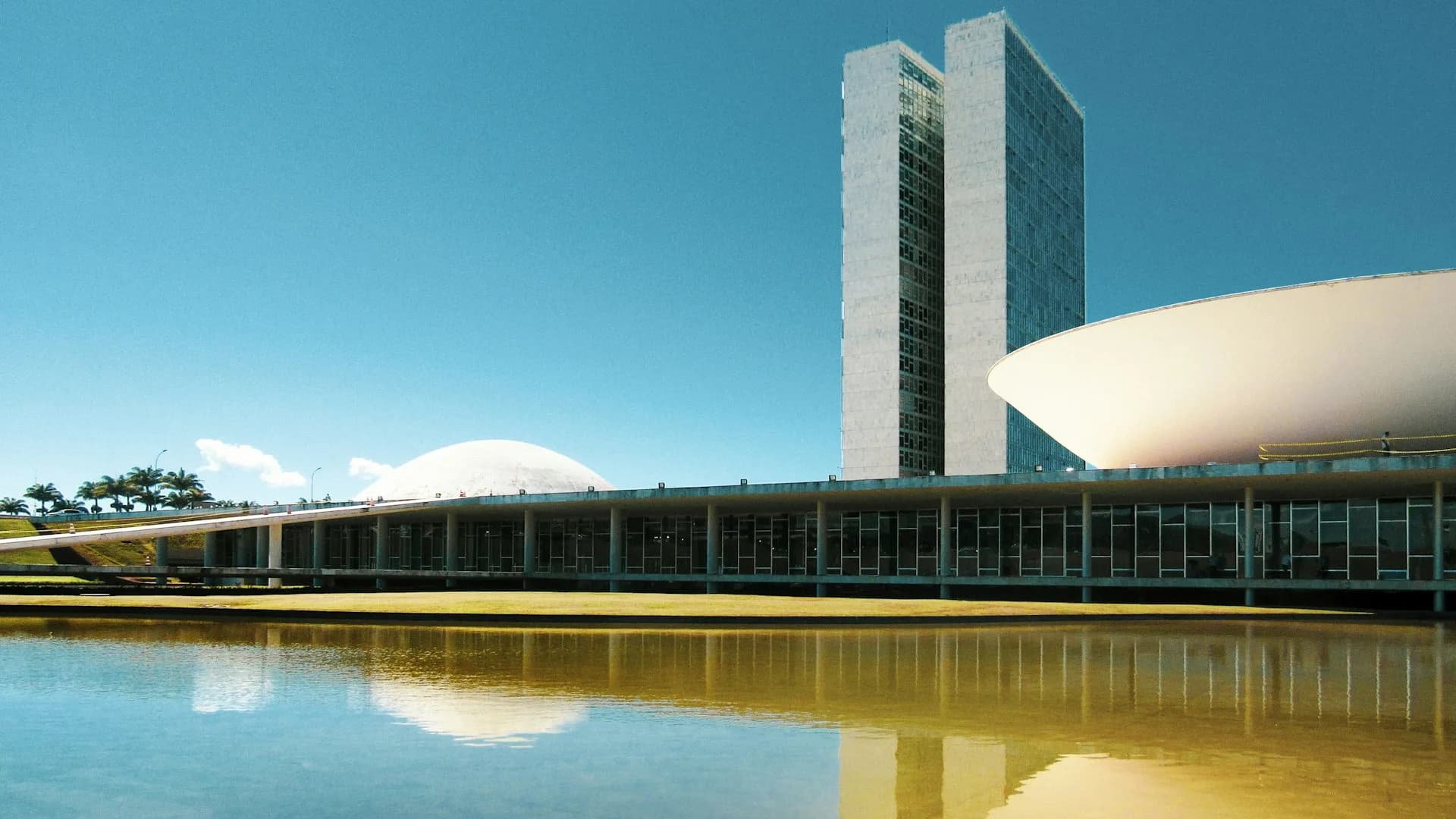 Congresso Nacional em Brasília ao entardecer com reflexo no espelho d'água